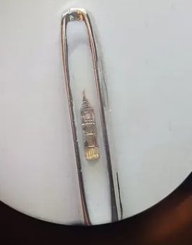 Big Ben in the eye of needle. Microart.