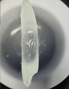 Micro Art. Silver Tulip on a grain of rice. Micro miniature.